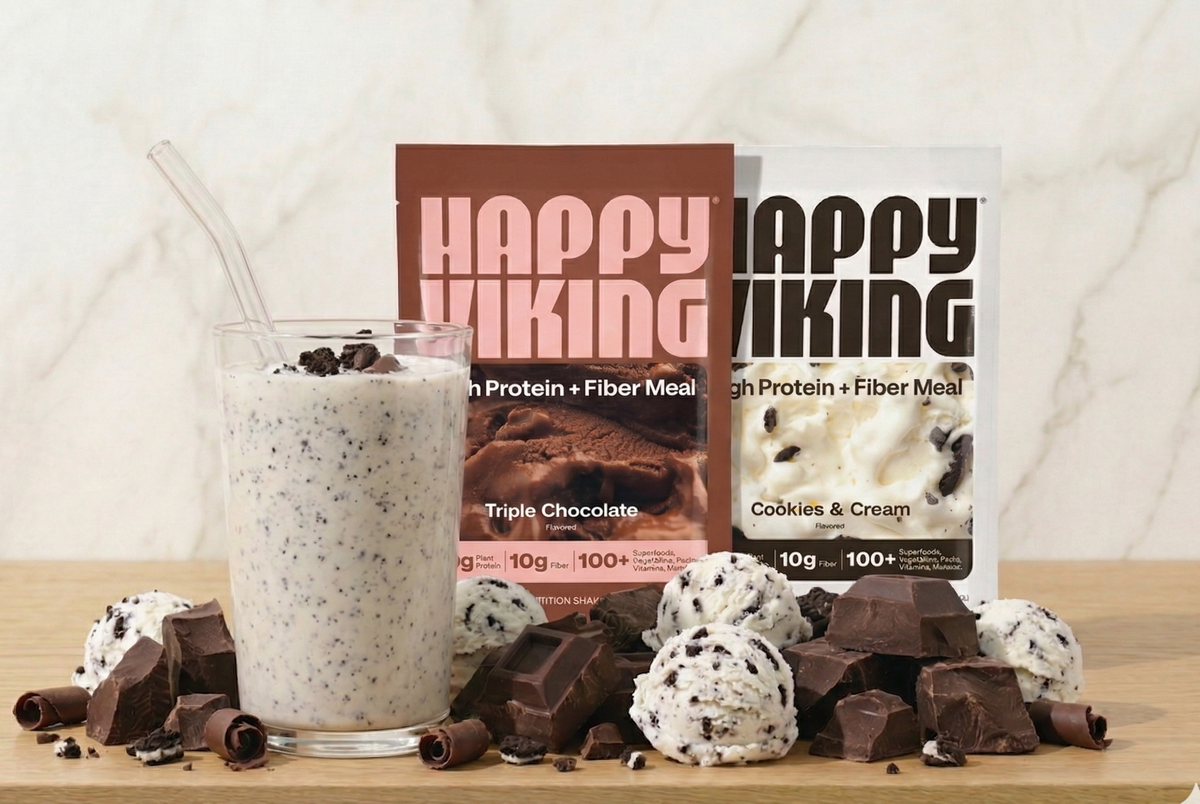 Happy Viking protein meal replacement shake with Triple Chocolate and Cookies & Cream flavors on a wooden surface.